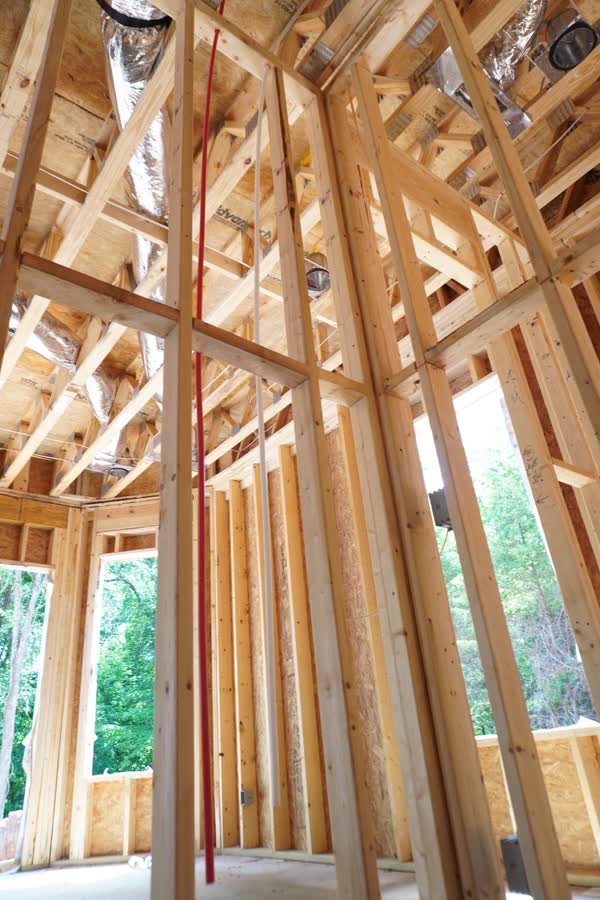 Two-storey framed great room with insulated ductwork overhead and a PEX riser run through the joists