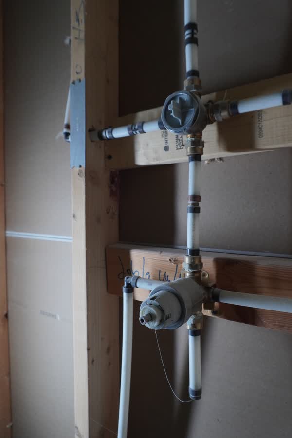 Valve assembly and PEX supply piping roughed into a utility wall